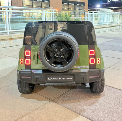 Rear view of a toy electric vehicle styled like a Land Rover Defender, featuring an olive green and black body